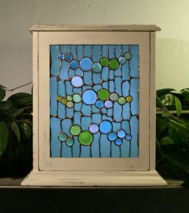 copper-foiled stained glass panel in vintage clock cabinet